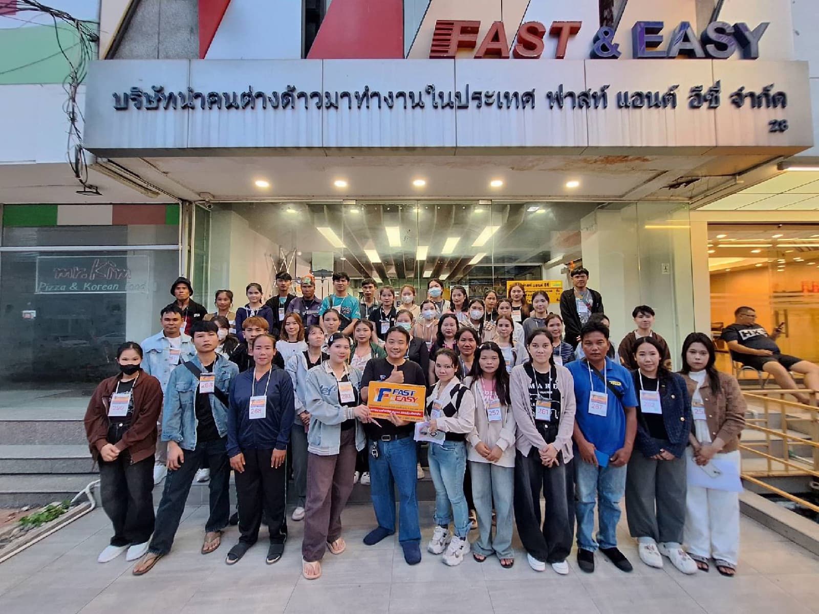 กลุ่มแรงงานต่างด้าวที่ ฟาสท์ แอนด์ อีซี่ ดูแลเอกสารให้ ถ่ายรูปหน้าสำนักงาน